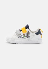 Sneakers bianchi con accenti grigi, blu navy e gialli. Presentano cinghie in velcro e un personaggio dei cartoni animati ricamato sul lato. Suola in gomma.