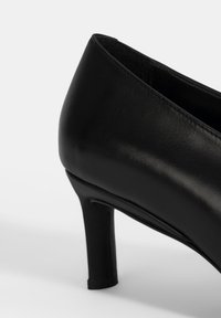 Zwart leren hoge hak schoenen met een slank, soepel afwerking, taps toelopend ontwerp en een hak van 5 cm. Binnenvoering voor comfort.