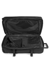 Valigia nera con ruote, con la cerniera aperta, caratterizzata da un ampio interno, materiale in nylon e numerose tasche per un'organizzazione ottimale.