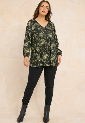 Musta yläosa vihreällä kukkakuviolla, V-pääntie, pitkät hihat, valuva muotoilu. Yhdistetty mustiin slim fit -farkkuihin ja nilkkureihin.