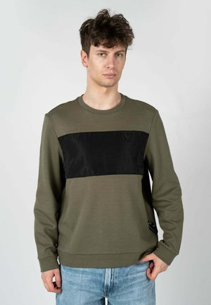 Sudadera verde oliva con un panel de satén negro en el pecho, cuello redondo y mangas largas. Presenta un sutil detalle del logo en el dobladillo.