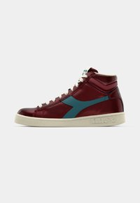 High-top sneakers in maroon leather with teal accents, white laces, and a textured off-white rubber sole. Features perforated detailing.