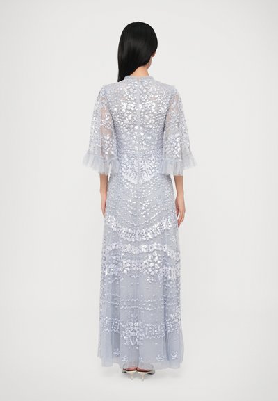 Μακρύ, ανοιχτό μπλε φόρεμα με στρωμένο, διαφανές σχέδιο. Διαθέτει κεντητά λουλουδένια μοτίβα και διαφανείς, βολάν μανίκια. Κλείνει με φερμουάρ στην πλάτη.