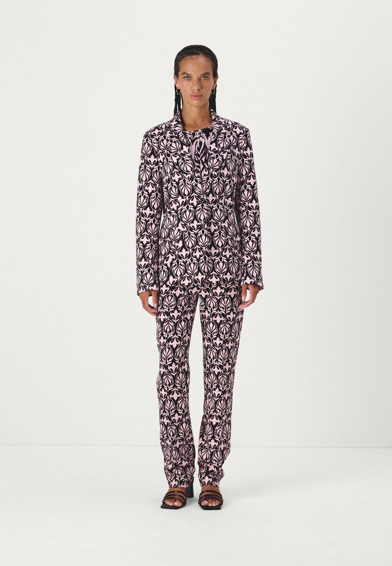 Pink floral patterned suit with a tailored jacket and matching pants. Made of lightweight fabric, featuring a slim fit and a smooth texture.