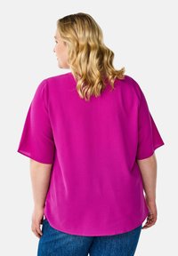 Magenta short-sleeve blouse with a relaxed fit, textured fabric, and a rounded neckline, seen from the back.