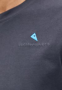 Donkerblauwe T-shirt van zachte katoen met een ronde hals. Bevat een blauw driehoekig logo en de merknaam geborduurd op de borst.