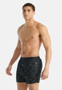 Černé boxerky s květinovým vzorem, elastickým pasem a malým logem vpředu. Hladký, lehký materiál.