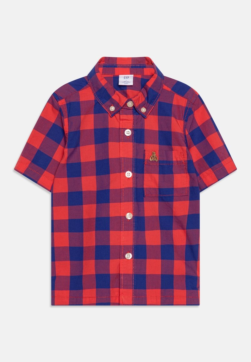 Chemise à manches courtes à carreaux rouges et bleus, boutonnée, avec col et petite poche poitrine comportant un emblème doré brodé.