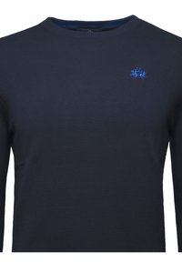 Merimustat pitkähihainen crewneck-paita ribbitetussa tekstuurissa, jossa on sininen brodeerattu logo rinnassa. Sileä kangas, klassinen malli.