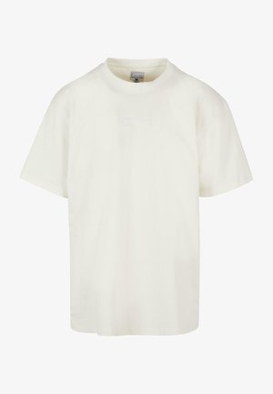 T-shirt en coton blanc avec un col rond, des manches courtes et un logo brodé discret à l'avant. Texture douce et coupe décontractée.