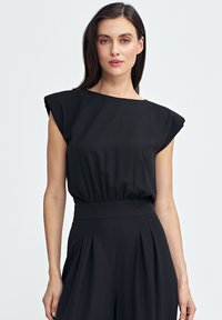 Czarny top z krótkimi, strukturalnymi rękawami i dopasowanym talią. Gładki, lekki materiał o subtelnym połysku. Minimalistyczny design.