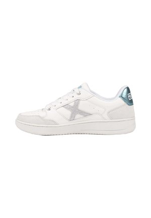 Zapatilla blanca de corte bajo con diseño en X de purpurina plateada en el lateral y pestaña metálica azul en el talón, orientada hacia la izquierda sobre un fondo blanco.