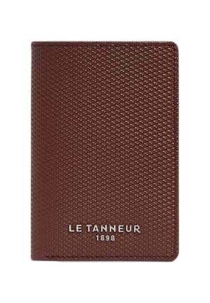 Portefeuille en cuir marron avec une surface texturée, présentant un logo argenté "LE TANNEUR 1898" en bas. Forme rectangulaire compacte.
