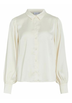 Blusa a maniche lunghe color crema con abbottonatura frontale, colletto a punta, spalle a sbuffo e polsini aderenti.