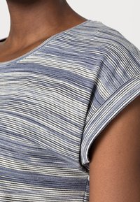 Top a rayas con diferentes anchos de líneas en azul, gris y blanco, con una textura suave y lisa y mangas cortas con puños.