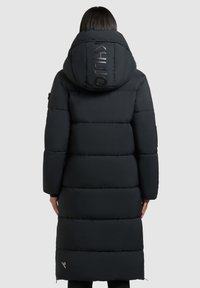 Zwarte pufferjas met een hoge kraag en grote capuchon, voorzien van horizontale stiksels en een logo-detail op de achterkant en onderrand.