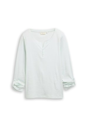 Haut à manches longues vert clair avec encolure arrondie, patte de boutonnage à l'avant et poignets retroussés ornés de boutons. Tissu doux et texturé.