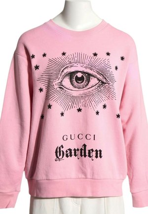 Różowa bluza z dużą czarną grafiką oka otoczoną gwiazdami i napisem ""GUCCI Garden"" z przodu.