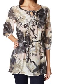 Tunic con motivo floreale in tessuto morbido e leggero. Presenta un colletto rotondo, dettagli con lacci, maniche a 3/4 e una vita stretto con cintura.