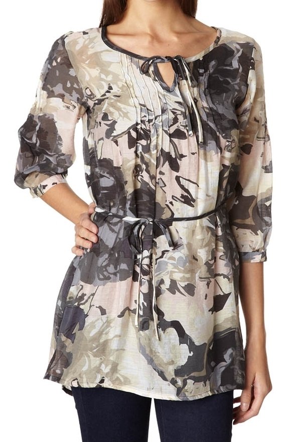 Tunic con motivo floreale in tessuto morbido e leggero. Presenta un colletto rotondo, dettagli con lacci, maniche a 3/4 e una vita stretto con cintura.