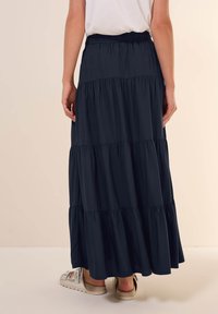 Gonna maxi a balze blu navy con cintura elastica e tessuto morbido e leggero. Decorata con cuciture arricciate ad ogni balza.