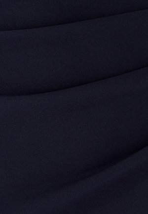 Tessuto di un blu navy scuro caratterizzato da una superficie liscia e testurizzata con pieghe sottili, creando un motivo ondulato su tutto il materiale.