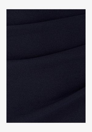 Ciemnoniebieska tkanina o gładkiej, teksturowanej powierzchni z subtelnymi fałdami, tworzącymi falisty wzór na materiale.