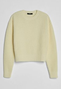 Sweter w kolorze kremowym, wykonany na drutach, z okrągłym dekoltem. Posiada ściągacze na mankietach i dole oraz teksturowany wzór na całej powierzchni.