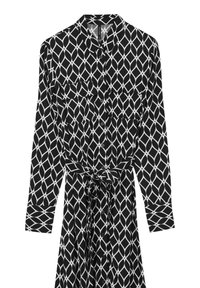 Robe à motifs noir et blanc avec des manches longues, un devant à boutons, deux poches poitrine et un détail de taille nouée. Présente un design géométrique.