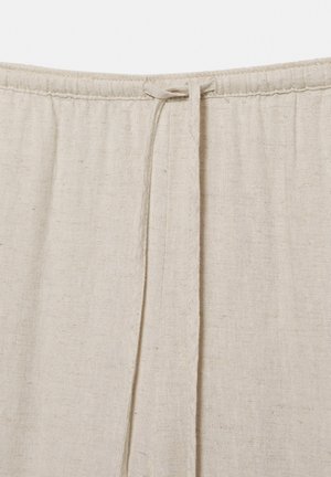 Beige linnen broek met tailleband en een aangetrokken trekkoord in het midden bovenaan.