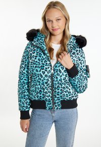 Giacca imbottita in teal con stampa leopardata nera, dotata di cappuccio in pelliccia sintetica, polsini a coste e chiusura zip anteriore con tasche laterali.