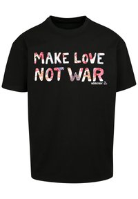 Black cotton T-shirt featuring the text "MAKE LOVE NOT WAR" in colorful patterned letters, with a Woodstock logo on the lower right.