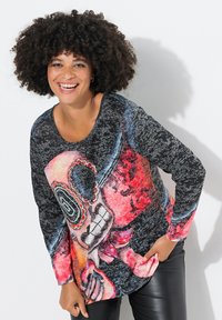 Long-sleeve black top featuring a vibrant skull design in red and blue. Soft material with a textured finish, relaxed fit, and rounded neckline.