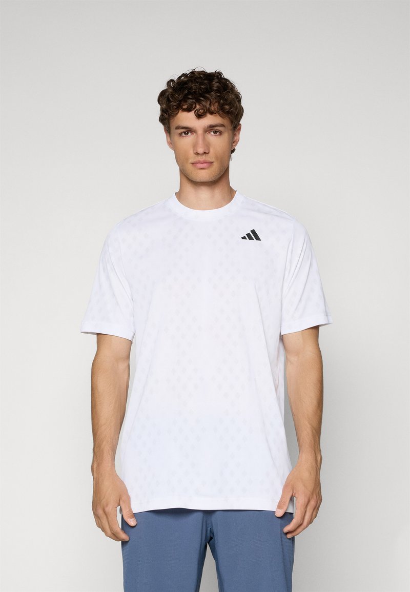 Weißes T-Shirt mit kurzen Ärmeln aus leichtem Material, das ein dezentes Diamantenmuster aufweist und ein schwarzes Adidas-Logo auf der Brust trägt.