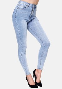 Jeans skinny de tiro alto color azul claro, hechos de denim, con cierre de cremallera y botón, dos bolsillos traseros y un ajuste ceñido.