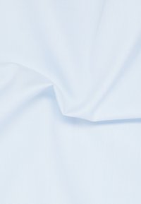 Tessuto azzurro chiaro con una superficie liscia e un leggero lucido, con delle pieghe in alcune zone, che mettono in evidenza le sue caratteristiche leggere e morbide.