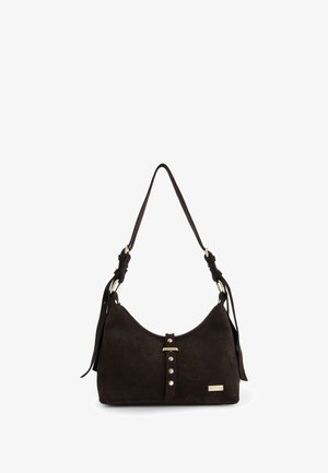 Sac à main en daim brun foncé avec une forme incurvée, une bandoulière ajustable, des accents en métal doré et une sangle décorative cloutée sur le devant.