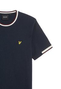 T-shirt in cotone blu navy con colletto rotondo, caratterizzato da strisce bianche e marrone bordeaux, e un piccolo logo ricamato di un'aquila gialla sul petto.