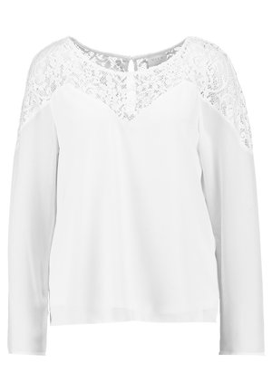Weiße Bluse mit langen Ärmeln, die ein Spitzen-Einsatzdesign aufweist. Glatte Textur, V-Ausschnitt und Schlüssel-Loch-Detail im Rücken. Schlichter, eleganter Stil.