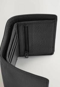 Sort læderpung med en struktureret overflade, der har flere kortholdere, et rum med lynlås og sort syning langs kanterne.
