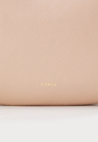 Borsa a tracolla in pelle rosa chiaro con finitura testurizzata. Logo dorato "Furla" in evidenza sulla parte anteriore. Superficie liscia e morbida.