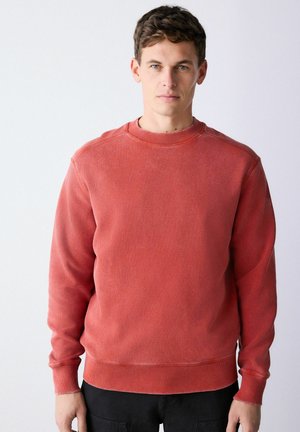 Roter Sweatshirt aus Baumwolle mit Rundhalsausschnitt, gerippten Bündchen und Saum. Der Stoff hat eine strukturierte Optik und eine entspannte Passform.