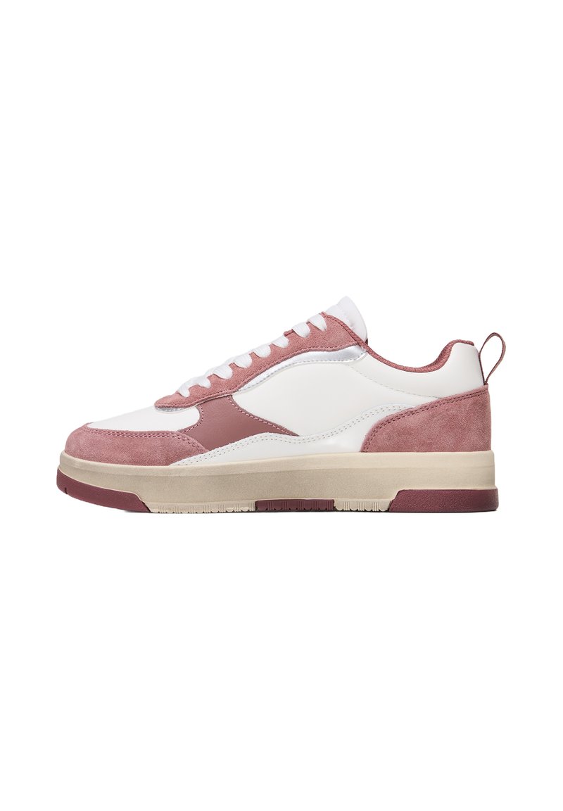 Vit sneaker med rosa mockadetaljer, rund tå, platta snören, gummisula och texturerad yta. Har en dragflik bak.