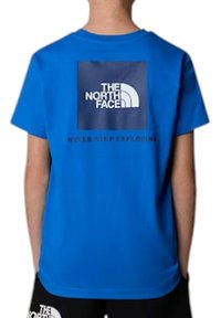 T-shirt azzurro a maniche corte con un logo rettangolare blu scuro che presenta "THE NORTH FACE" e la frase "NEVER STOP EXPLORING" sotto di esso.