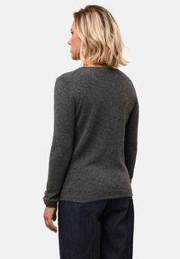 Grijze lange mouwen trui in een zachte textuur, met een ronde halslijn en aansluitende mouwen, gecombineerd met donkere denim broeken.