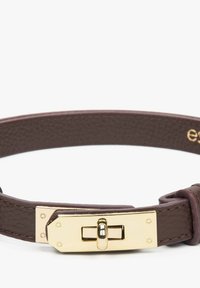 Brązowa skórzana bransoletka z prostokątną zapięciem w złotym odcieniu, ozdobioną okrągłymi akcentami oraz widocznym przeszyciem wzdłuż krawędzi.