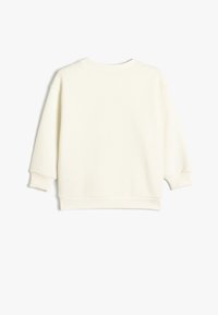 Krämfärgad sweatshirt med en avslappnad passform, rund hals och ribbad mudd. Mjukt material med en jämn textur och inga synliga mönster.