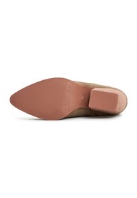 Suola di una scarpa in camoscio beige con punta appuntita, suola esterna in gomma marrone chiaro e tacco a blocco medio. Taglia indicata come 39 sulla suola.