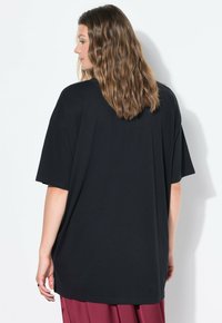 Zwart oversized t-shirt met korte mouwen, gemaakt van zachte stof, met een ronde halslijn en een relaxte pasvorm.