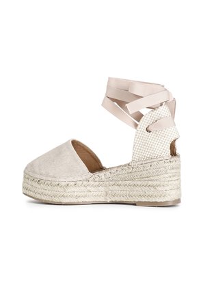 Wedge espadrille beige con tomaia in tessuto testurizzato, punta rotonda e soletta in juta intrecciata. Presenta cinturini in nastro incrociati alla caviglia.